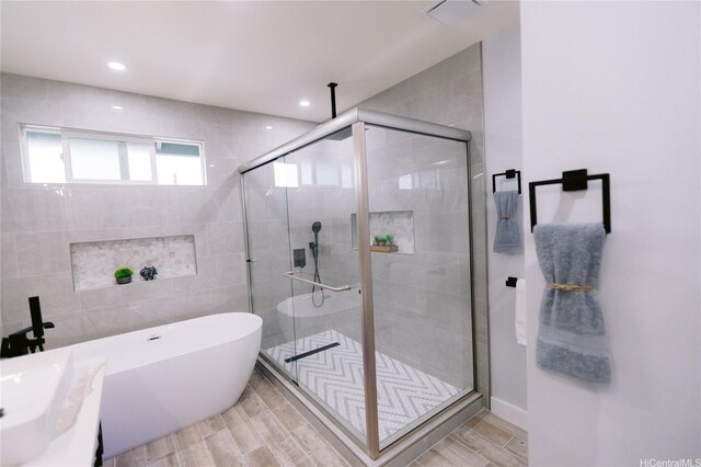 92-1310 Palahia St, Kapolei, HI 96707 - full bath featuring a shower stall, a freestanding bath, tile walls, wood finished floors, and recessed lighting