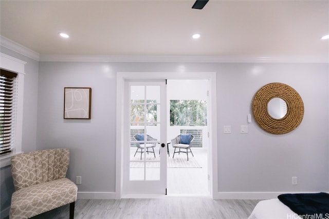 interior space featuring ceiling fan, light hardwood / wood-style flooring, and ornamental molding