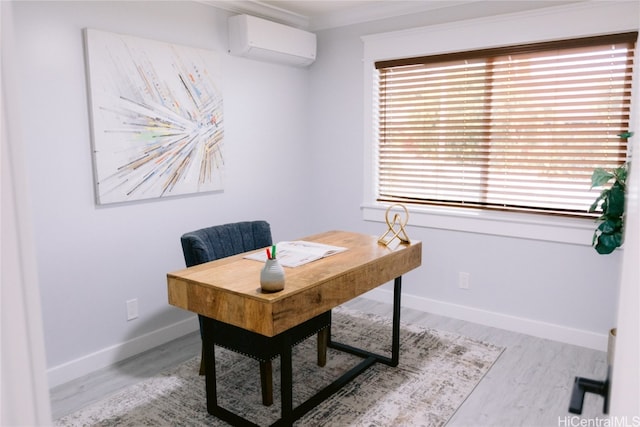 office space featuring light wood-type flooring, plenty of natural light, an AC wall unit, and ornamental molding