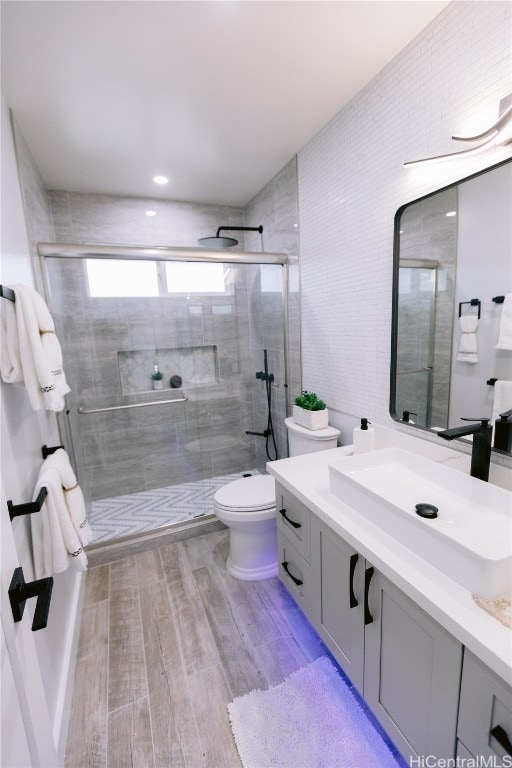 bathroom with hardwood / wood-style floors, an enclosed shower, and vanity