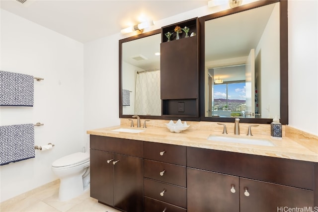 bathroom with tile patterned flooring, vanity, and toilet