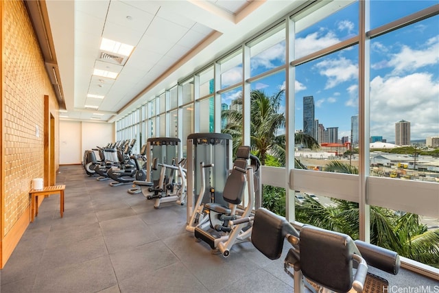 workout area featuring expansive windows and brick wall