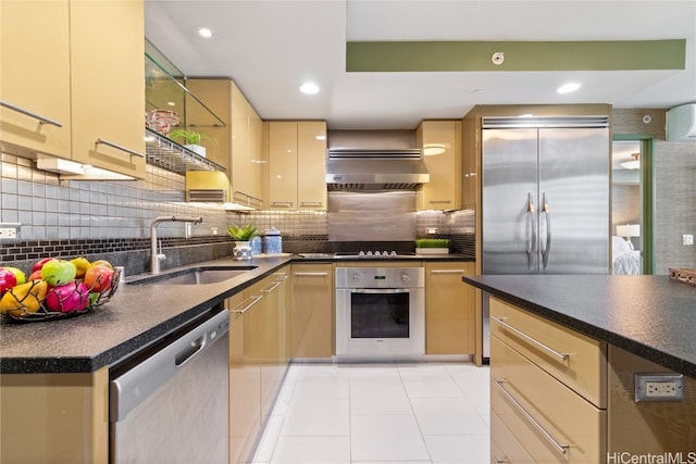 kitchen featuring tasteful backsplash, ventilation hood, stainless steel appliances, light brown cabinets, and sink