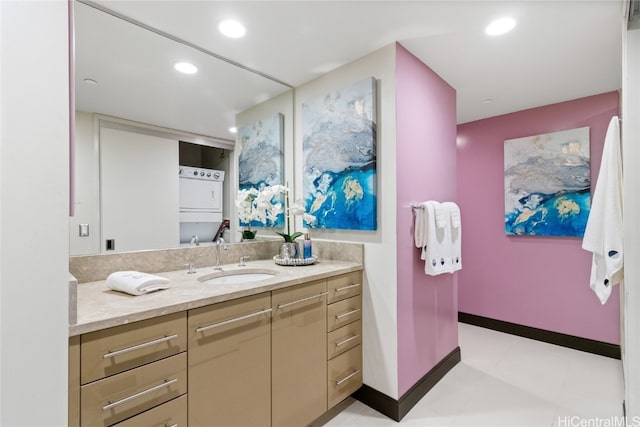 bathroom with vanity and stacked washer and clothes dryer