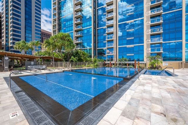 view of swimming pool with a patio and an in ground hot tub