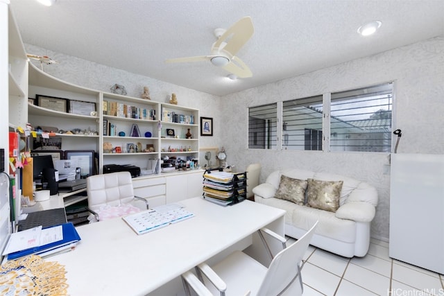 home office featuring ceiling fan, light tile patterned floors, and a textured ceiling