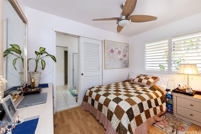 bedroom featuring ceiling fan, a closet, and light hardwood / wood-style floors