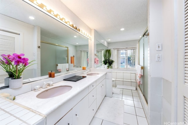 bathroom with vanity, a textured ceiling, tile patterned floors, and a shower with shower door