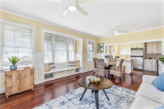 living room featuring ceiling fan, dark wood-type flooring, and ornamental molding