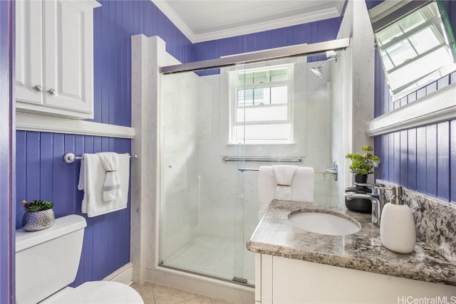 bathroom with tile patterned flooring, crown molding, toilet, a shower with door, and vanity