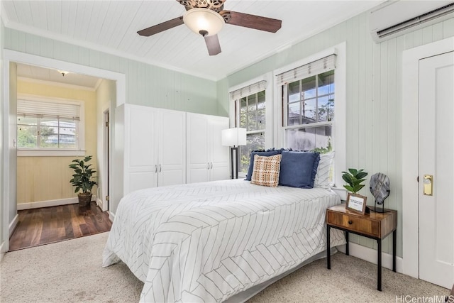 bedroom with ceiling fan, an AC wall unit, ornamental molding, and multiple windows