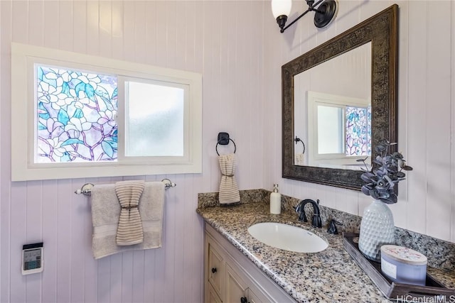 bathroom featuring wood walls and vanity