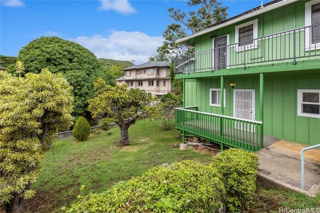 view of yard with a balcony and a deck