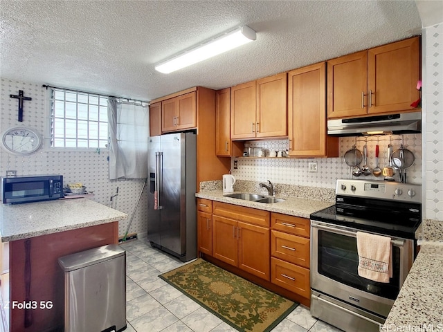 kitchen featuring stainless steel appliances, a textured ceiling, light tile patterned floors, light stone countertops, and sink