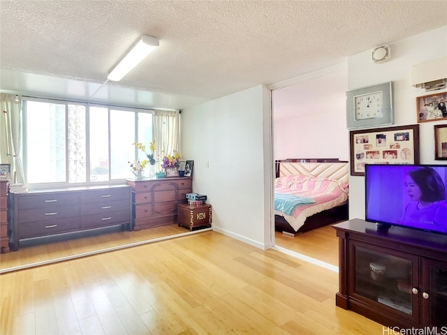 bedroom with light wood-type flooring and a textured ceiling