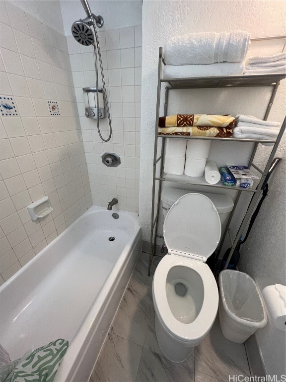 bathroom featuring tiled shower / bath and toilet