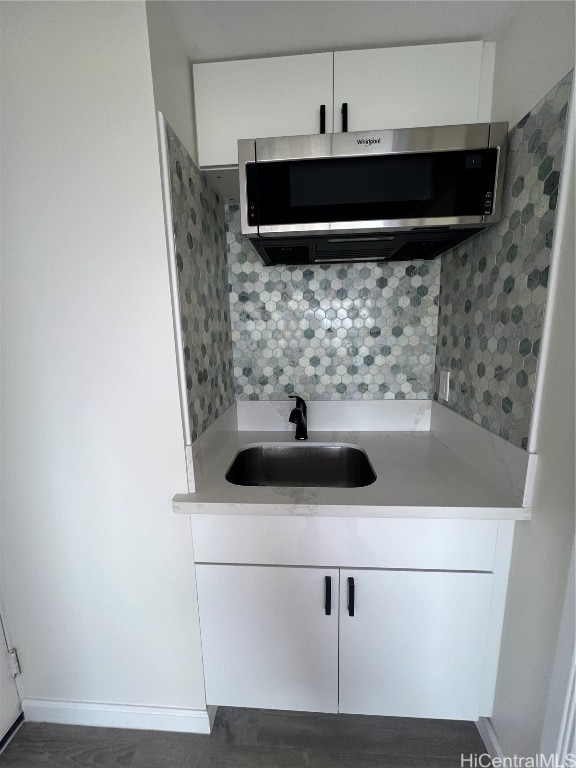 kitchen featuring white cabinets, sink, and decorative backsplash