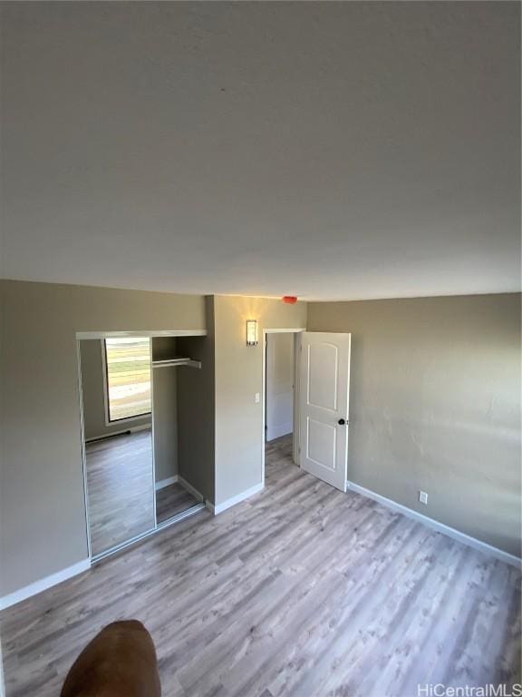 unfurnished bedroom featuring a closet and light wood-type flooring