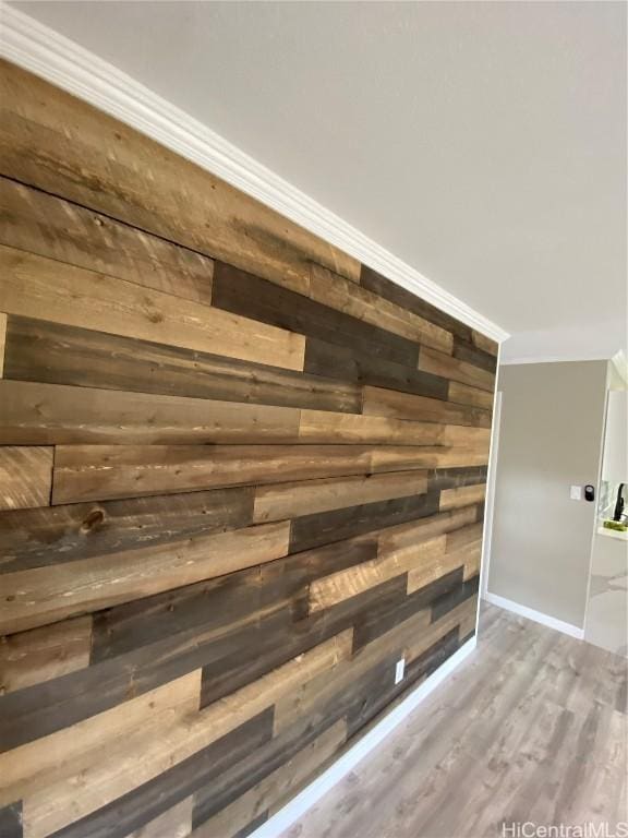 interior details with hardwood / wood-style floors, crown molding, and wooden walls