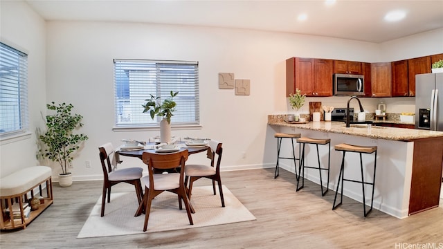 dining area featuring light hardwood / wood-style floors, a healthy amount of sunlight, and sink