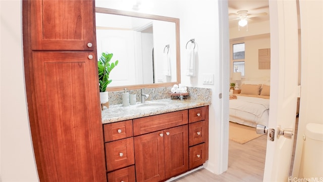 bathroom with ceiling fan, wood-type flooring, vanity, and toilet