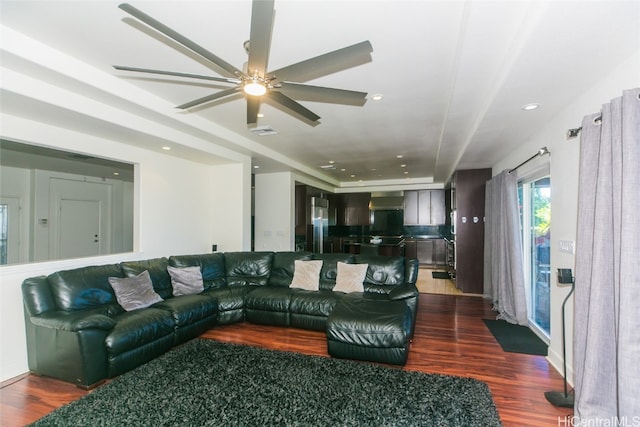 living room with ceiling fan and dark wood-type flooring