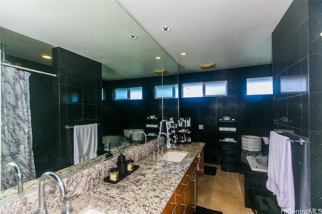 bathroom with tile patterned flooring, plenty of natural light, tile walls, and vanity