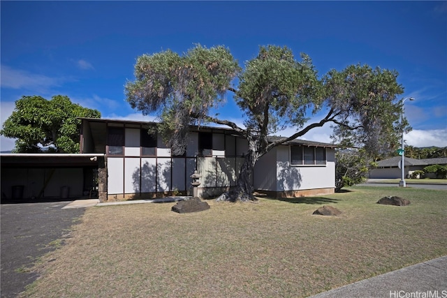 view of front of house with a front yard and a carport