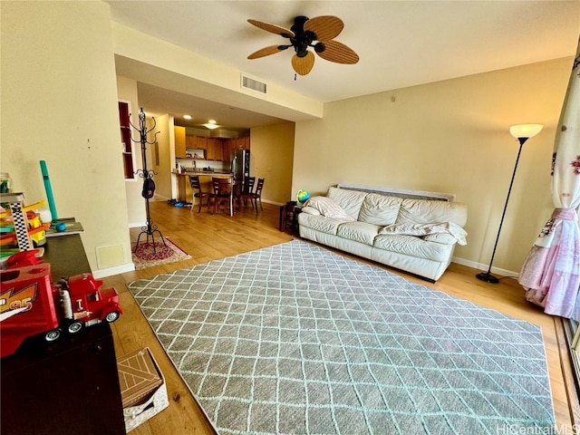 living room with ceiling fan and light hardwood / wood-style flooring