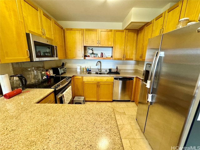 kitchen with sink, light stone counters, and stainless steel appliances