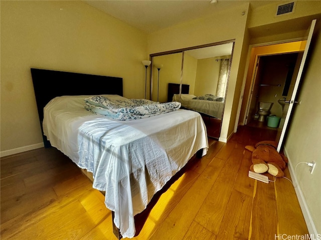 bedroom with wood-type flooring and a closet