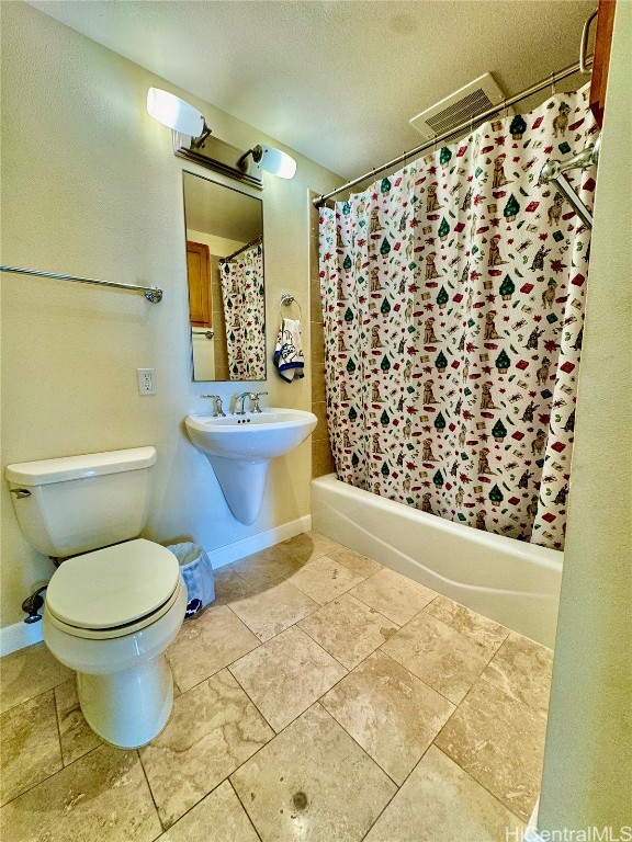 bathroom featuring toilet, sink, and a textured ceiling