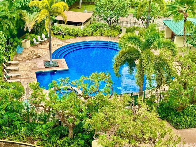 view of swimming pool featuring a hot tub and a patio area