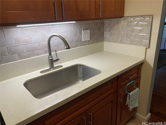 kitchen with tasteful backsplash, sink, and light stone counters