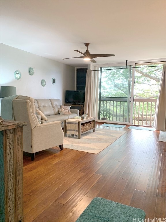 living room with floor to ceiling windows, hardwood / wood-style floors, and ceiling fan