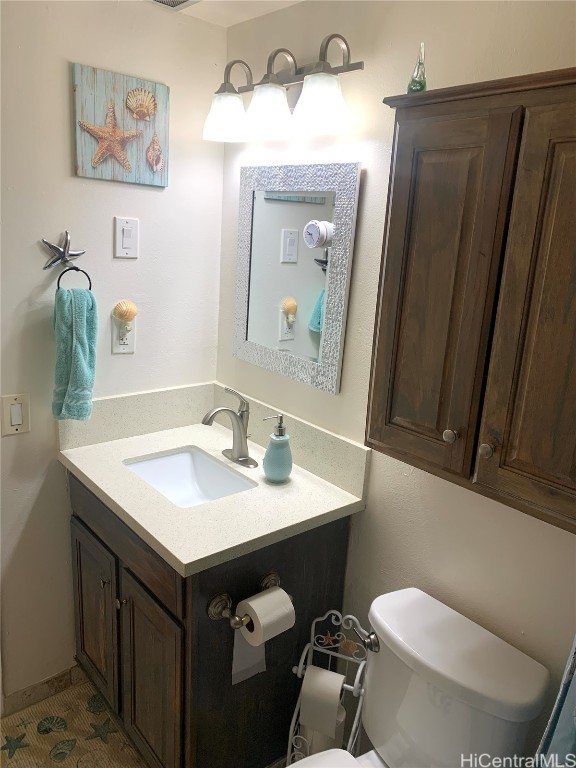 half bath featuring vanity, toilet, and tile patterned floors