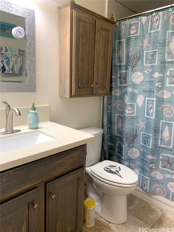 bathroom with a shower with curtain, vanity, toilet, and tile patterned floors