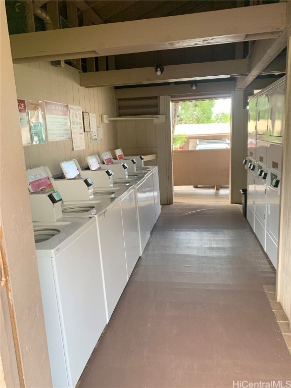 laundry area with independent washer and dryer and wooden walls