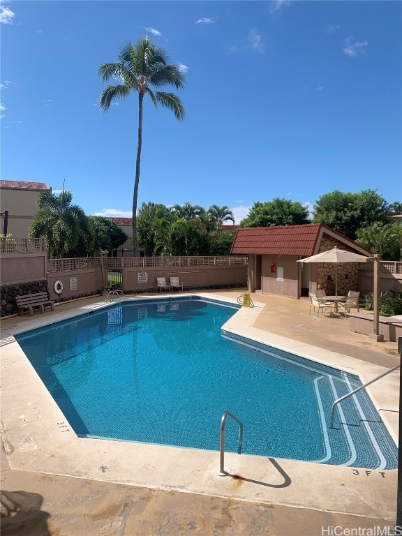 pool with a patio and fence