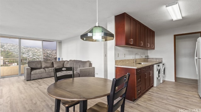 kitchen with a mountain view, light wood-type flooring, washer and dryer, and sink