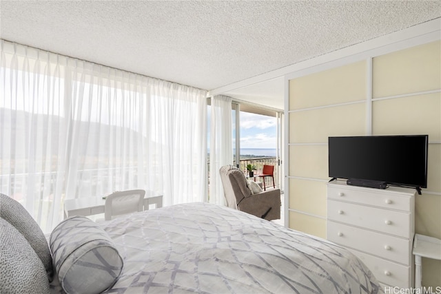 bedroom with access to outside and a textured ceiling