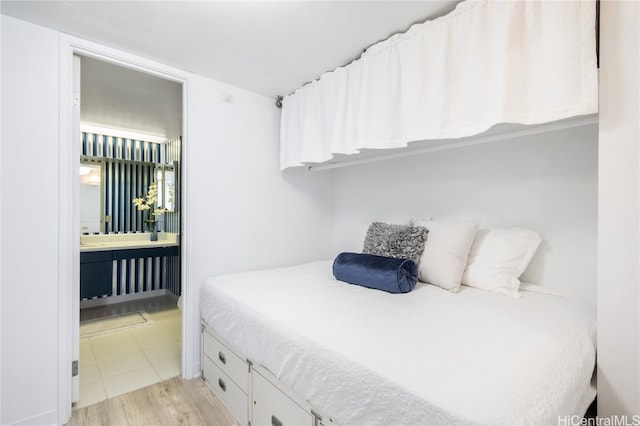 bedroom featuring light hardwood / wood-style floors and connected bathroom