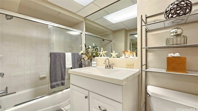 full bathroom featuring bath / shower combo with glass door, vanity, and toilet