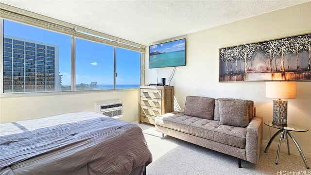 carpeted bedroom featuring a wall unit AC and a textured ceiling