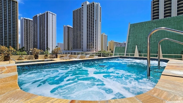 view of swimming pool featuring a view of city and fence