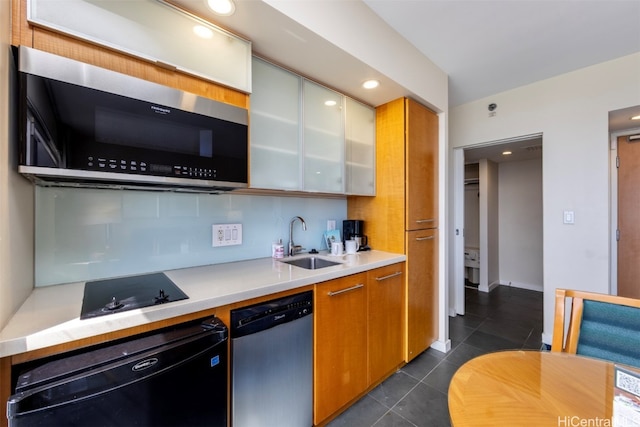 kitchen featuring dark tile patterned flooring, backsplash, appliances with stainless steel finishes, and sink