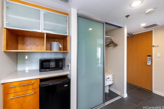 kitchen featuring black appliances and dark tile patterned floors