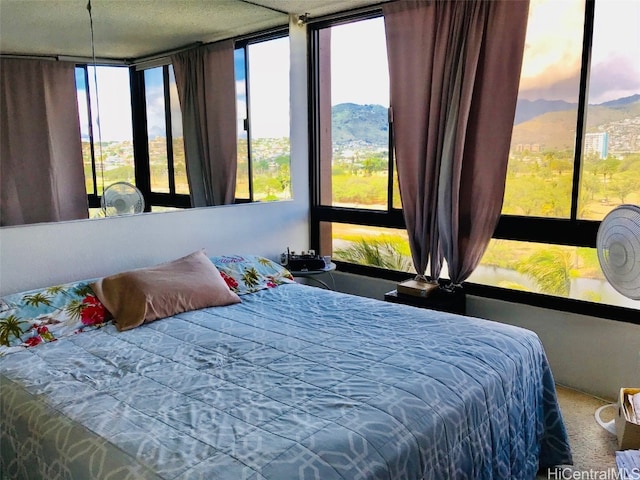 carpeted bedroom featuring expansive windows and a mountain view