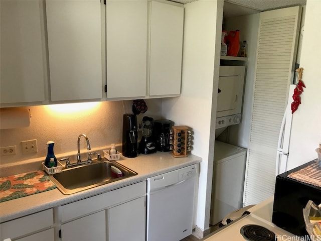 kitchen featuring stacked washer / drying machine, white cabinetry, sink, and white dishwasher