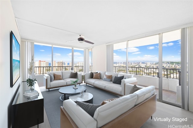 living room featuring ceiling fan, light wood-type flooring, and floor to ceiling windows